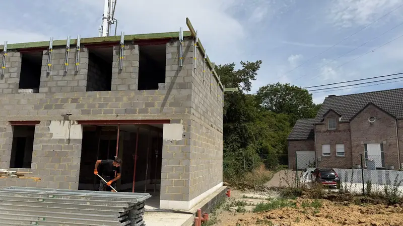 Maison en construction : murs en blocs béton montés jusqu'au premier étage